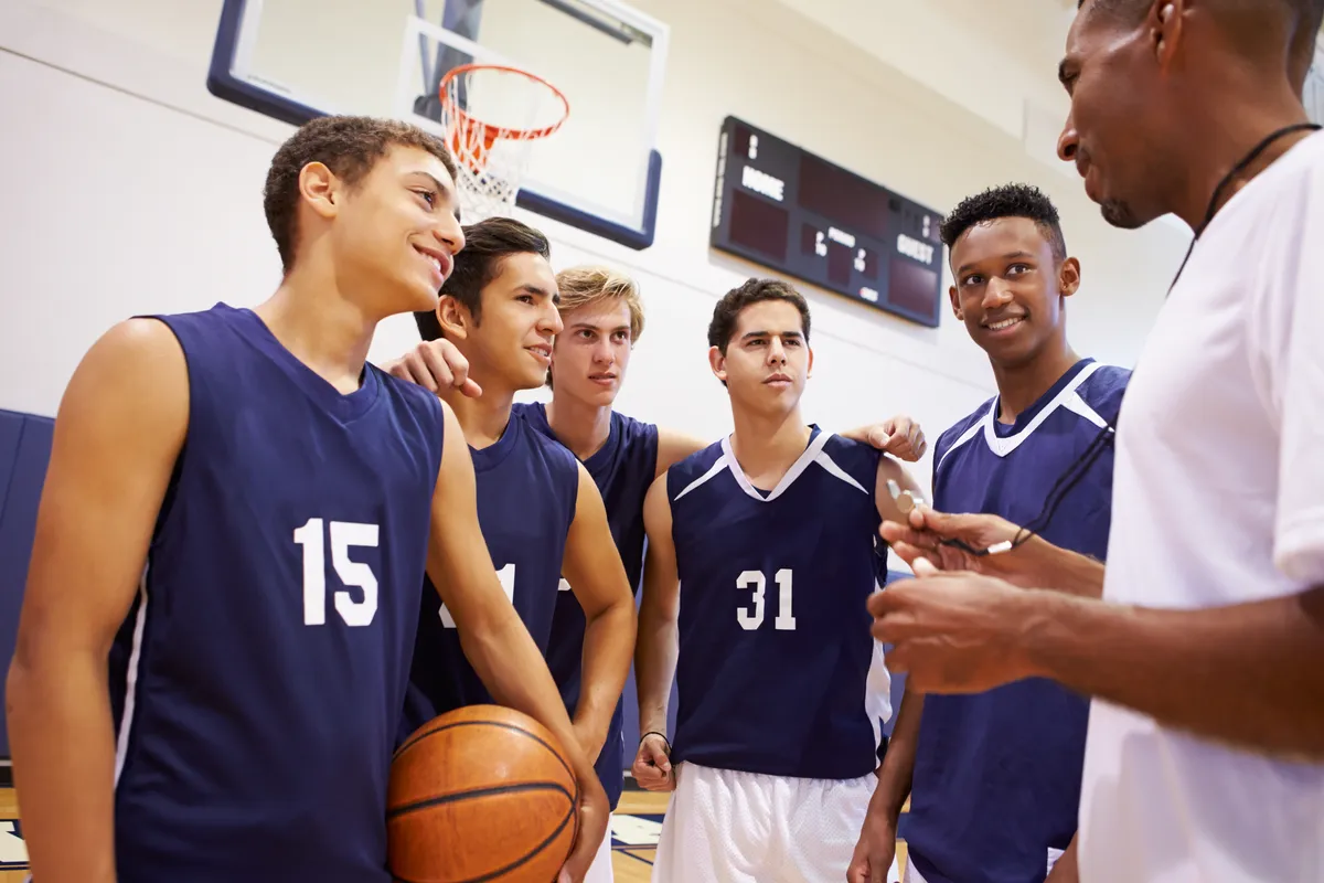Coach in a huddle with young basketball players