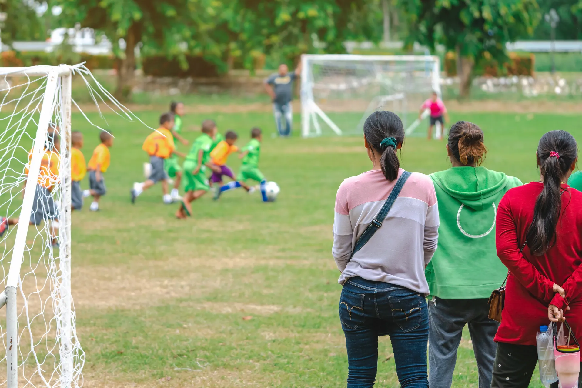 Parents watching a youth soccer game from the sidelines